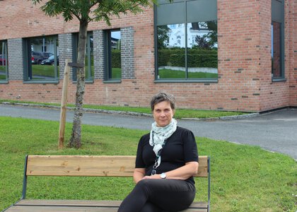 Rektor som sitter på en benk utenfor skolen - Klikk for stort bilde